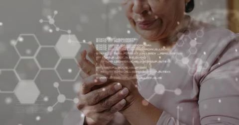 Image of processing data, dna and elements over pained biracial woman rubbing Fotos Stock