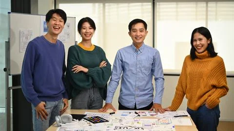 Image of professional developer team standing at co working space and smiling Stock Photos