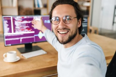 Image of programmer man showing screens while taking selfie photo Stock Photos