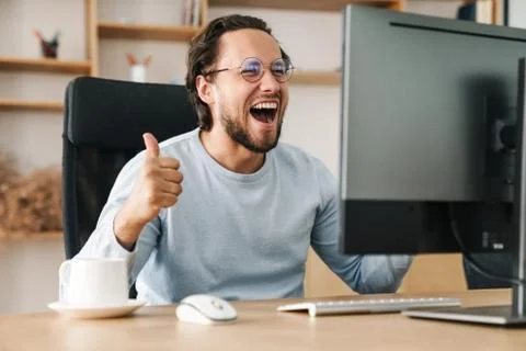 Image of programmer man showing thumb up while working with computer Stock Photos