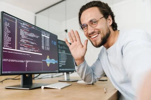 Image of programmer man waving hand while working with computers Stock Photos