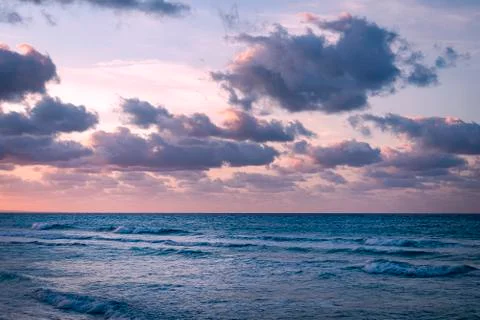 Image of purple dramatic sky at sunset with clouds over sea. Stock Photos