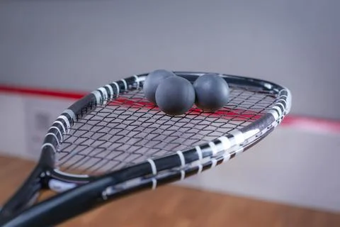 Image of racket and three squash balls. Sports concept. Stock Photos