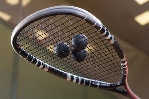 Image of racket and three squash balls. Sports concept. Stock Photos