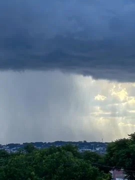 Image of rain on the horizon, with the left side showing rain and the right s Stock Photos