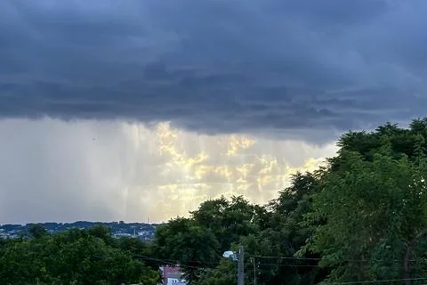 Image of rain on the horizon, with the left side showing rain and the right s Stock Photos