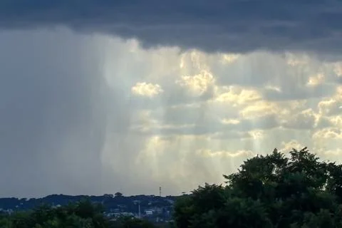 Image of rain on the horizon, with the left side showing rain and the right s Stock Photos