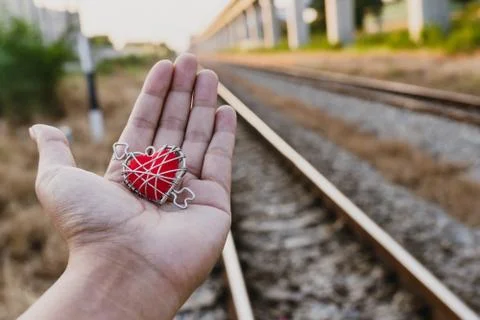 The image of the red heart on the hand of the old train track background Stock Photos
