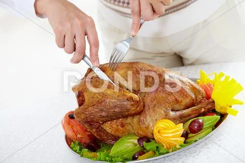 Image of roasted turkey being cut by knife and fork on festive table Stock-Fotos