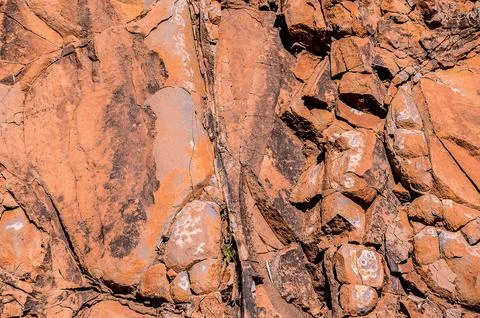 The image is of a rocky surface with a lot of texture and a reddish color Stock Photos
