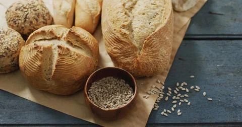 Image of rolls and bread on baking paper on wooden worktop Stock-Fotos