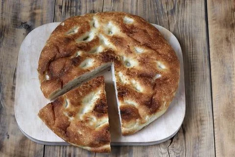 The image of round bread on a cutting board from which a small fraction is .. Foto stock