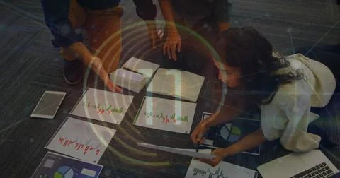 Image of round scanner and diverse colleagues discussing over documents at Foto stock