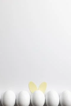 Image of row of white easter eggs with bunny ears and copy space on white Foto stock