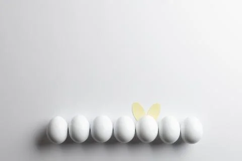 Image of row of white easter eggs with bunny ears and copy space on white Foto stock