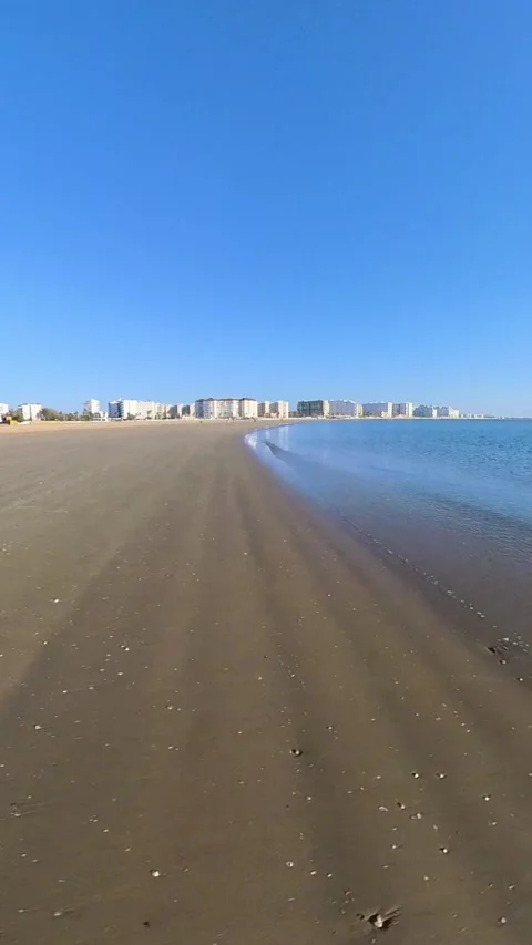 Image running through the sea water ending in the sun on the beach. Relax. 4K Stock Footage 265806216