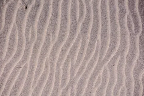 The image is of a sandy beach with a wave pattern Foto stock