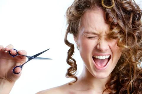 Image of screaming young girl trying to cut her hair off Stock Photos