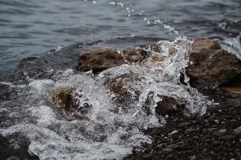 Image of the sea surf. A large wave is beating against a stone on the seashore Stock Photos