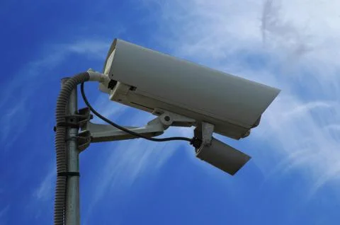 Image of a security camera with the sky in the background Stock Photos