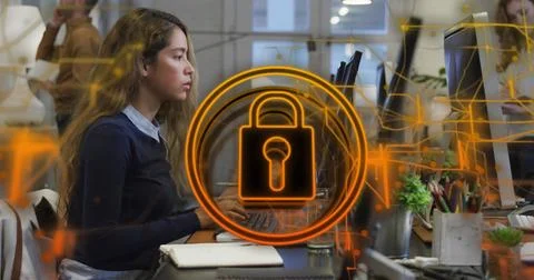 Image of security padlock icon against biracial woman using computer at offic Stock Photos