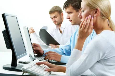 Image of serious business partners typing in working environment Stock Photos