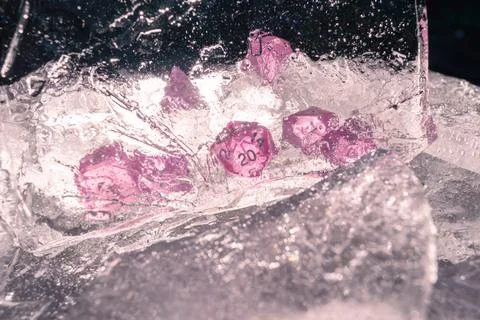 Image of a set of rpg dice behind a sheet of ice in the sun light. Focused on Stock Photos