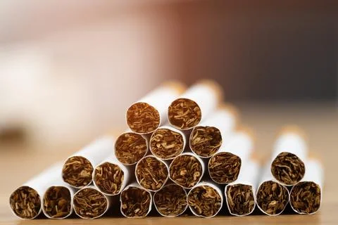 Image of several commercially made cigarettes. pile stack cigarette on wood.. Foto stock