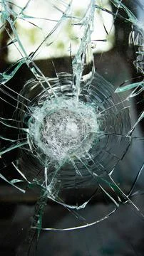 Image of a shattered window with a clear point of impact and radiating cracks Stock Photos