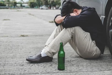 Image of shocked and scared driver after accident involved lying on the road Stock Photos