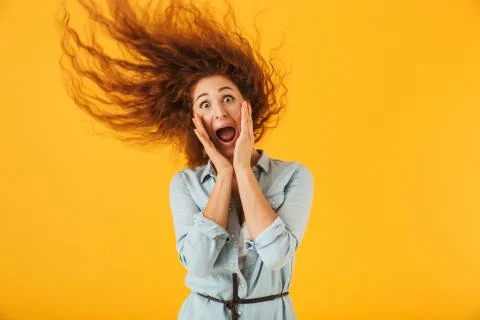 Image of shocked or surprised woman 20s with shaking hair grabbing face and s Stock Photos