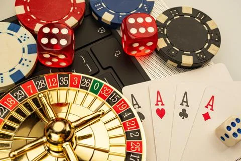 Image showcases a casino setting with playing cards, roulette wheel, dice, .. Stock Photos