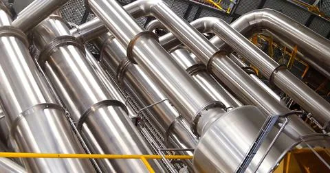 The image showcases an extensive network of stainless steel pipes and machine Stock Photos