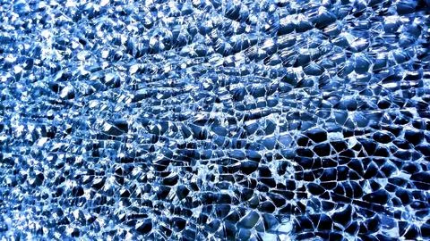 The image showcases a mesmerizing texture of shattered glass, reflecting light Stock Photos