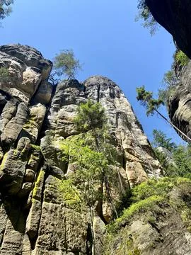 The image showcases towering rock cliffs adorned with sparse vegetation and.. Stock Photos