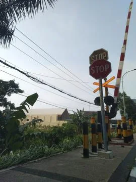 An image showing a level crossing with a "STOP" sign prominently displayed. Stock Photos
