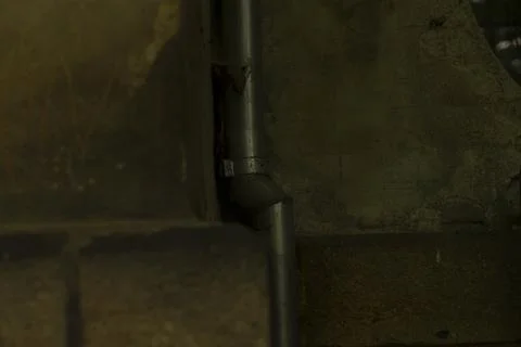 Image showing textured rusty pipe against rough wall background Stock Photos