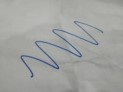 The image shows a blue, continuous, wavy line drawn on a piece of white paper Stock Photos