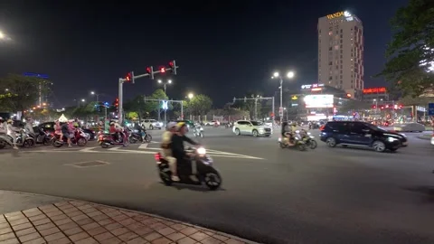 The image shows a busy nighttime intersection in Da Nang, Vietnam. Stockbeeldmateriaal 329953052