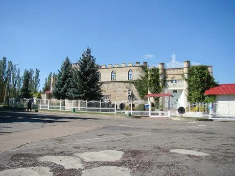 Image shows a castle-like building with multiple turrets and red roof, surrou Foto stock