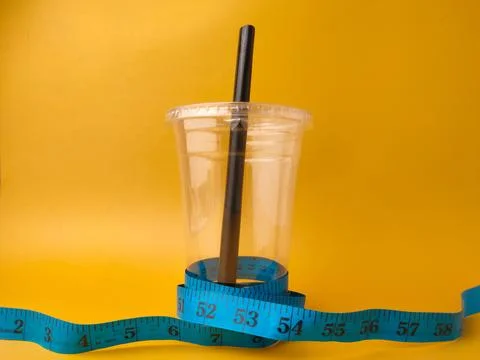 The image shows a clear disposable plastic cup with a black straw, encircle.. Stock Photos
