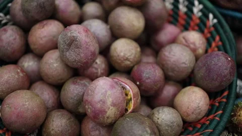 This image shows a close-up shot of passion fruits in a basket, with some fruits Stock Footage 303286490