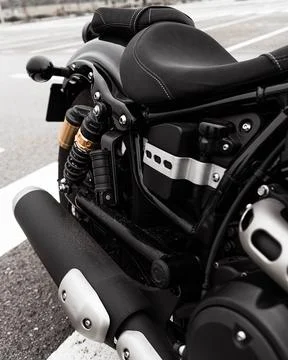 The image shows a close-up view of a black motorcycle parked on the side of a Stock Photos