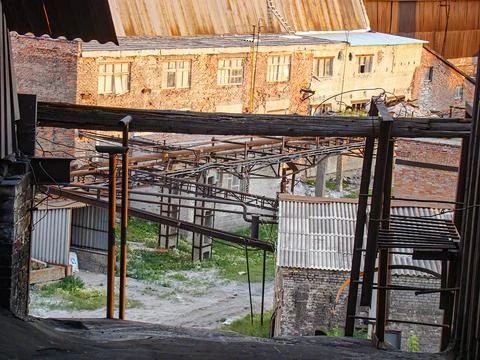 Image shows a dilapidated interior of a building, with exposed beams, debri.. Stock Photos