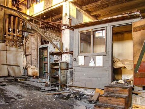 Image shows a dilapidated interior of an old building or warehouse with deb.. Stock Photos