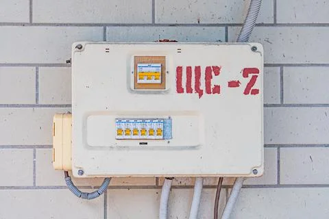 Image shows electrical box on a tiled wall, possibly part of a building ext.. Stock Photos