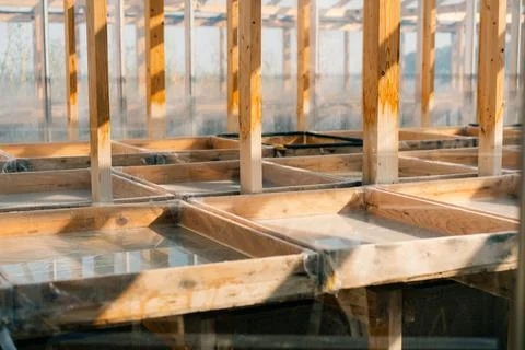 The image shows the inside empty of a greenhouse Stock Photos