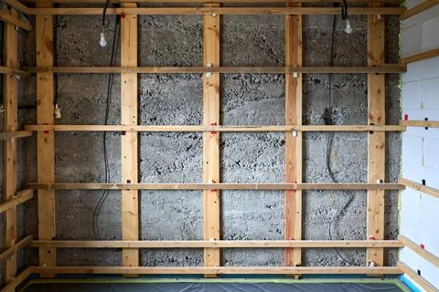 The image shows an interior wall covered with a grid-like wooden framing stru Stock Photos
