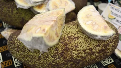 This image shows jackfruits with some pieces sliced off, revealing the yellow pu Stock Footage 303286518