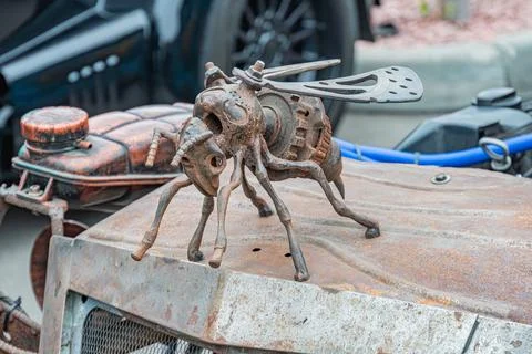 Image shows a metallic, insect-like robot beewasp, perched on an old vehicle  Stock Photos